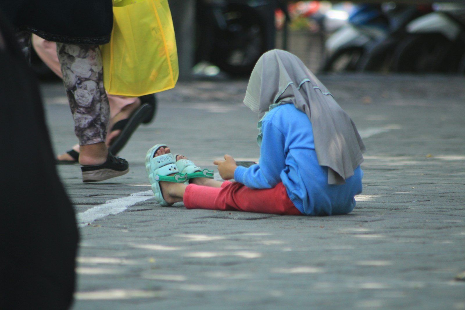 A person sitting on the ground with their head on the ground